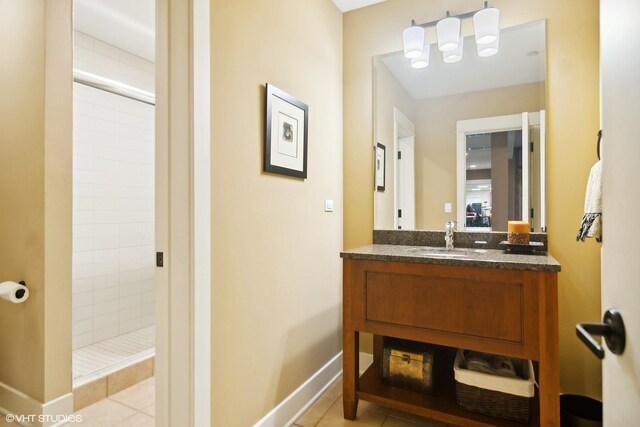 bathroom featuring tiled shower, vanity, and tile patterned flooring