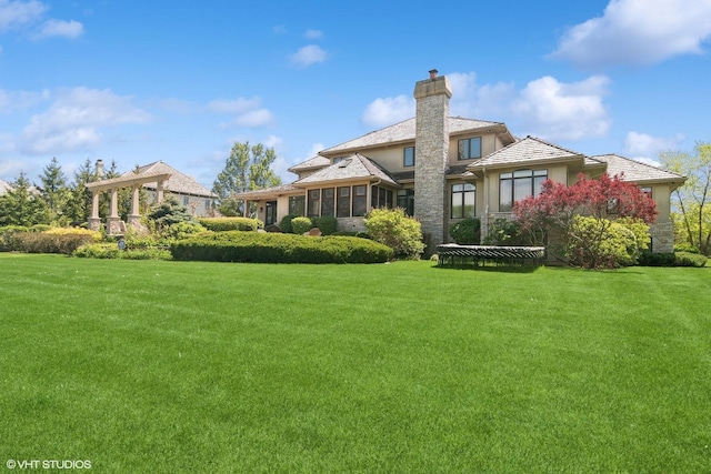 back of property featuring a yard and a sunroom