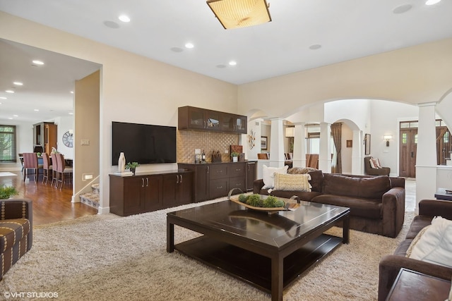 living room featuring light carpet and decorative columns