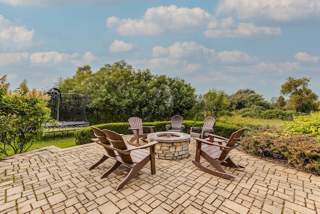 view of patio / terrace with a trampoline and an outdoor fire pit