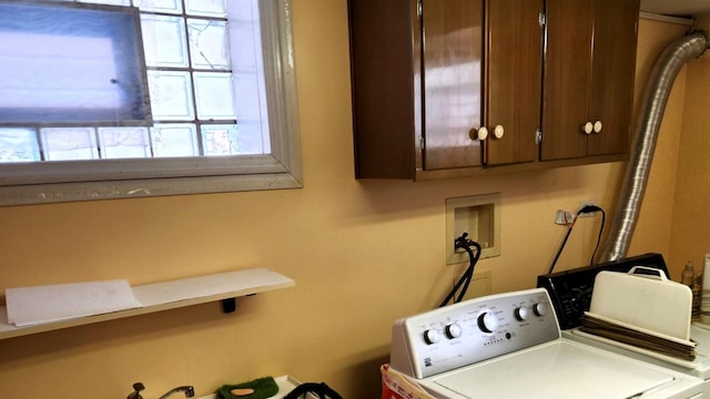 laundry area featuring washing machine and clothes dryer and cabinets