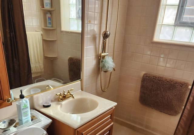 bathroom featuring toilet, vanity, a wealth of natural light, and walk in shower