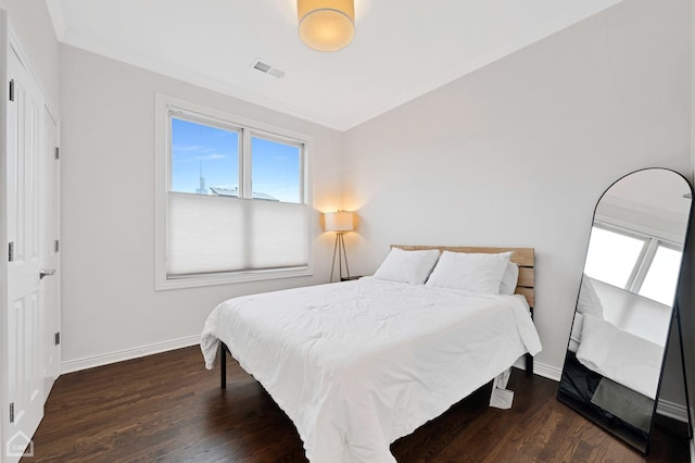 bedroom with crown molding and dark hardwood / wood-style flooring