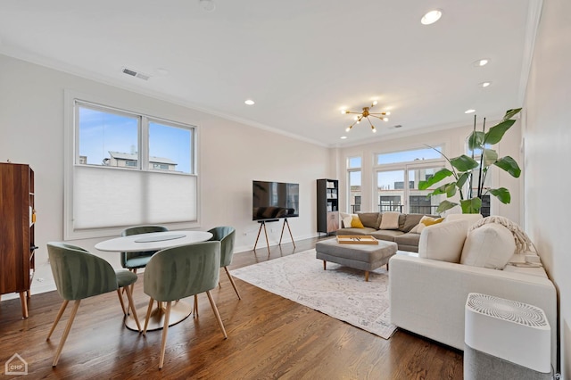 living room featuring an inviting chandelier, ornamental molding, dark hardwood / wood-style floors, and a wealth of natural light