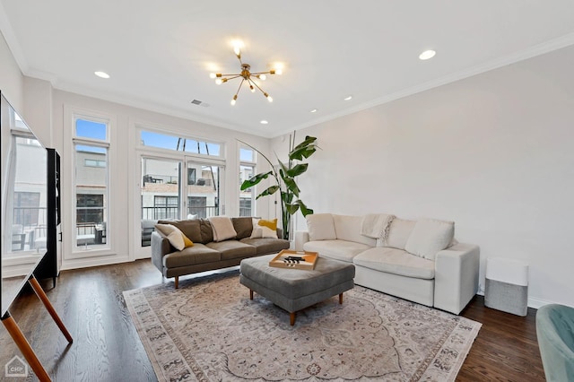 living room featuring dark wood-type flooring, ornamental molding, and a chandelier