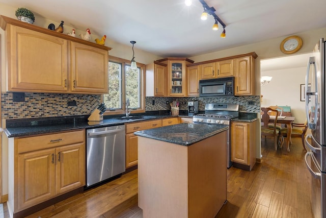 kitchen with stainless steel appliances, dark wood-type flooring, sink, a center island, and hanging light fixtures