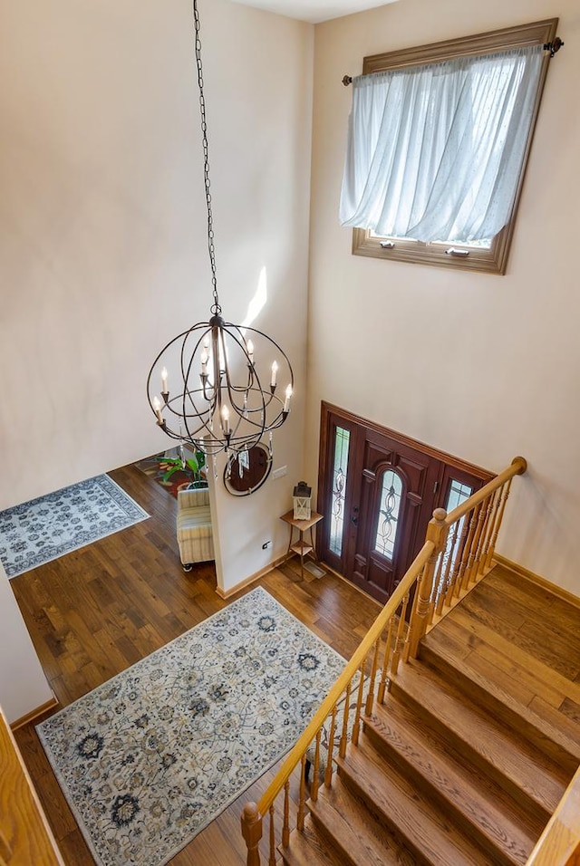 entryway with wood-type flooring and a notable chandelier