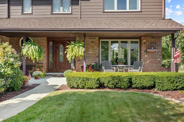 doorway to property featuring a lawn and a porch