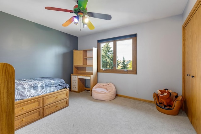 carpeted bedroom featuring ceiling fan and a closet