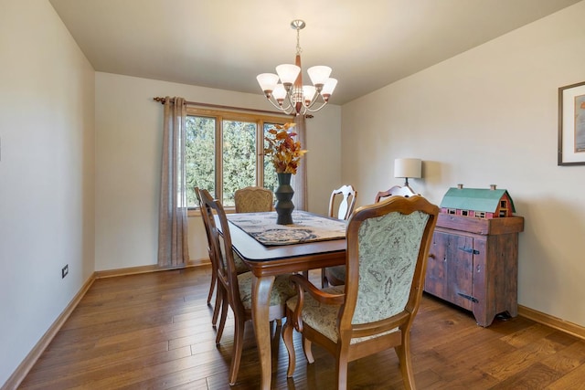 dining space featuring dark wood-type flooring and a notable chandelier