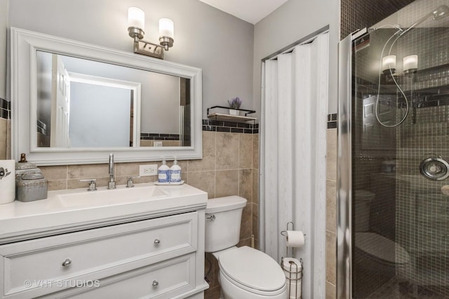 bathroom with decorative backsplash, vanity, tile walls, toilet, and a shower with shower door