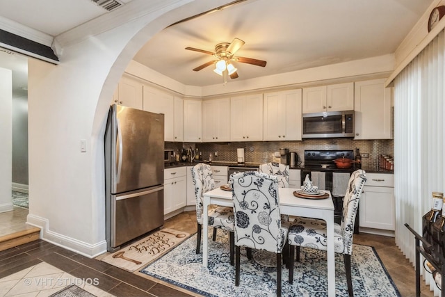 kitchen featuring backsplash, white cabinetry, ceiling fan, and appliances with stainless steel finishes