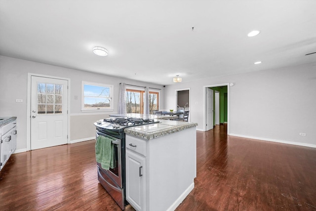 kitchen with gas stove, dark hardwood / wood-style floors, and white cabinetry