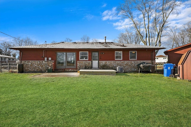 rear view of house featuring central AC unit and a yard