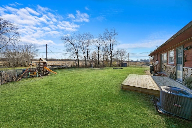 view of yard featuring a playground, central AC unit, and a deck