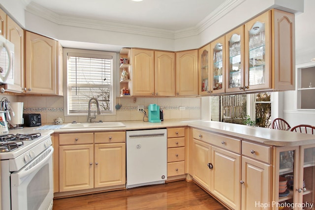 kitchen with light brown cabinets, white appliances, backsplash, sink, and kitchen peninsula