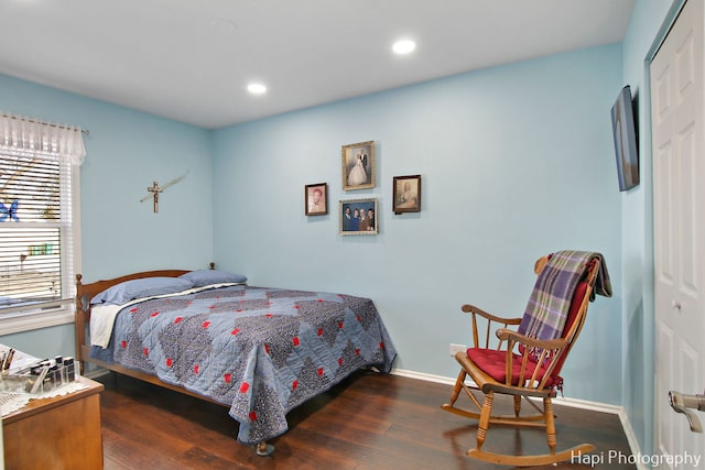 bedroom with dark hardwood / wood-style flooring and a closet