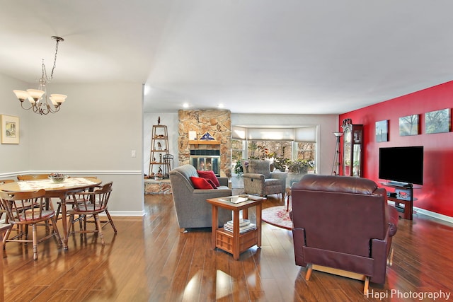 living room with a fireplace, hardwood / wood-style flooring, and a notable chandelier