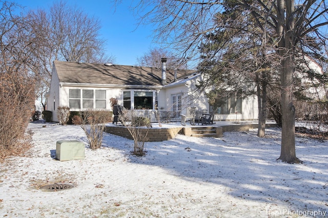 view of snow covered back of property