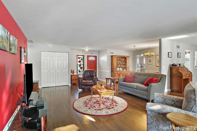 living room featuring dark wood-type flooring and a notable chandelier