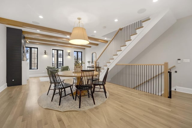 dining room with beam ceiling and light hardwood / wood-style floors