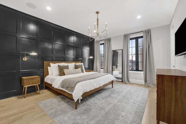 bedroom with an inviting chandelier and light wood-type flooring