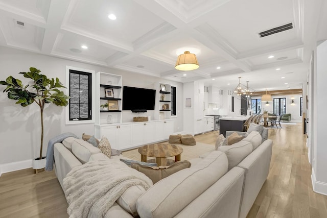 living room featuring coffered ceiling, crown molding, a chandelier, beam ceiling, and light hardwood / wood-style floors