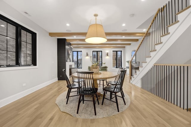 dining room featuring beam ceiling and light hardwood / wood-style floors