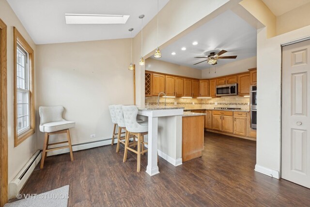 kitchen featuring sink, backsplash, lofted ceiling with skylight, light stone countertops, and stainless steel fridge with ice dispenser