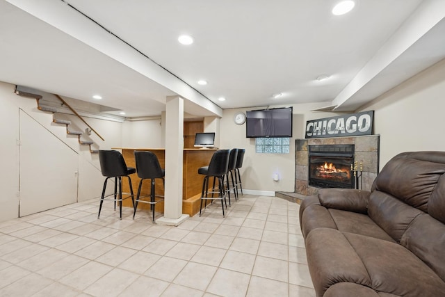 bar with light tile patterned floors and a tile fireplace