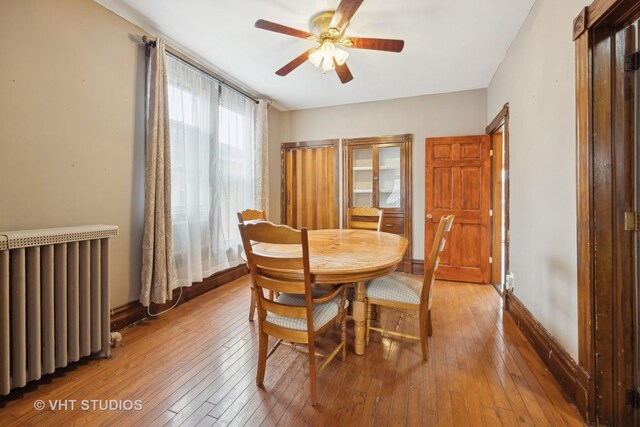 dining area with hardwood / wood-style flooring, ceiling fan, radiator, and a wealth of natural light