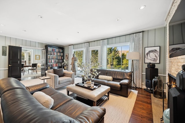 living room featuring recessed lighting, a stone fireplace, and wood finished floors