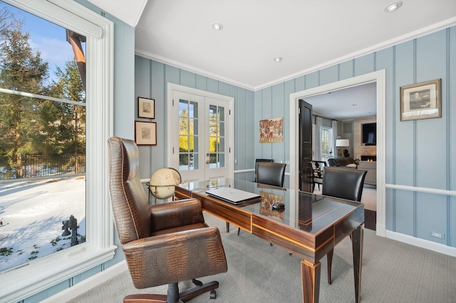 carpeted office space featuring a large fireplace, crown molding, and french doors