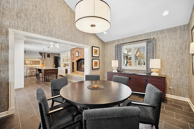 dining area with tile patterned floors, lofted ceiling, recessed lighting, and wallpapered walls