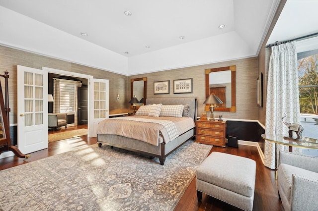 bedroom with recessed lighting, dark wood-style flooring, french doors, a raised ceiling, and wallpapered walls