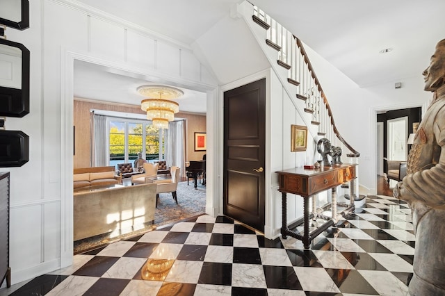 interior space with a chandelier, stairway, a decorative wall, and ornamental molding