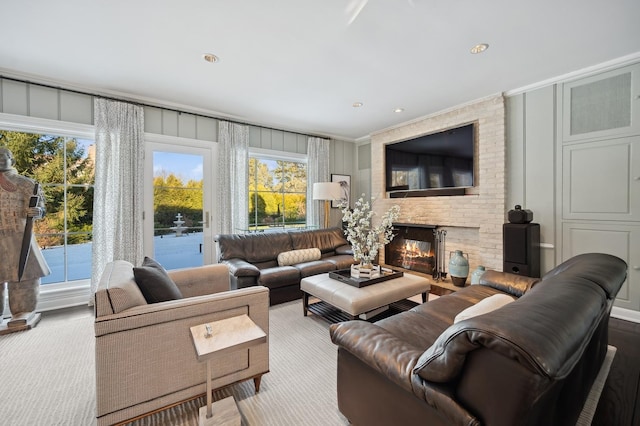 living area with a brick fireplace, a decorative wall, wood finished floors, and recessed lighting