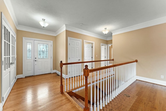 foyer with light wood-type flooring and ornamental molding