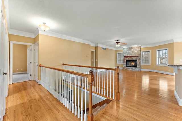 hallway featuring light wood-type flooring and ornamental molding