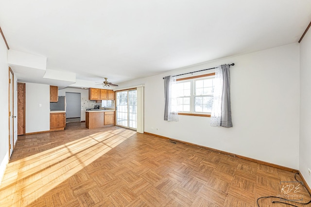 unfurnished living room featuring ceiling fan and light parquet floors