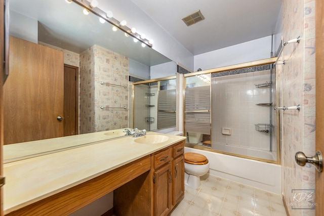 full bathroom with shower / bath combination with glass door, vanity, and toilet