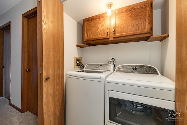 washroom featuring washing machine and dryer, cabinets, and carpet floors