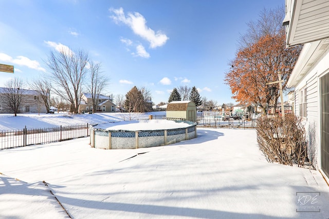 yard layered in snow featuring a storage unit