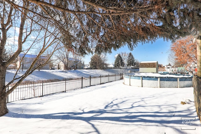 yard covered in snow with a covered pool