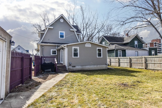 back of house featuring crawl space, a fenced backyard, and a yard