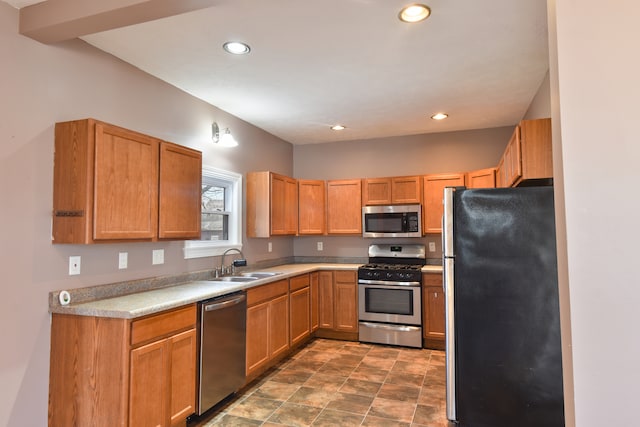 kitchen featuring stainless steel appliances, recessed lighting, light countertops, and a sink