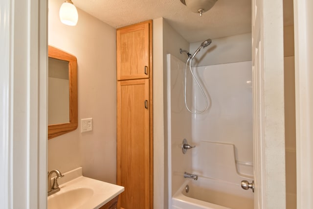 full bath featuring  shower combination, a textured ceiling, and vanity