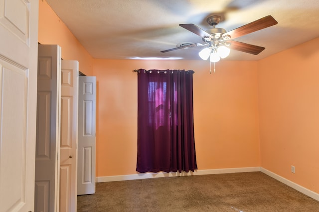 unfurnished room featuring carpet floors, baseboards, and a ceiling fan