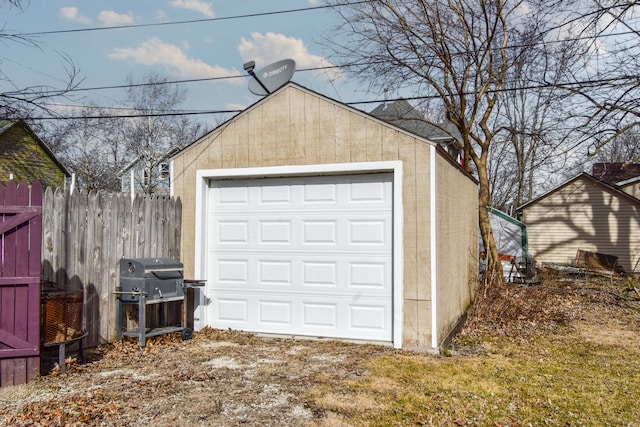 detached garage featuring fence