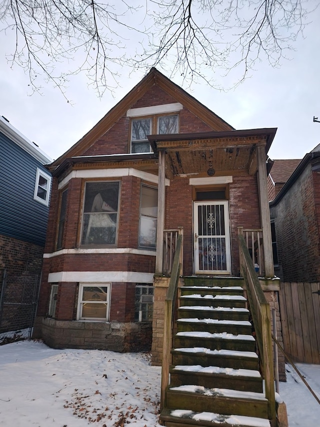 view of front facade featuring fence and brick siding